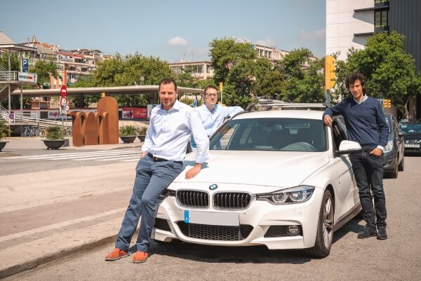 Josep Maria Torras, Marc Boher from Urbiotica and Ignasi Vilajosana from Worldsensing posing next to a BMW car in Plaça de Sants in Barcelona